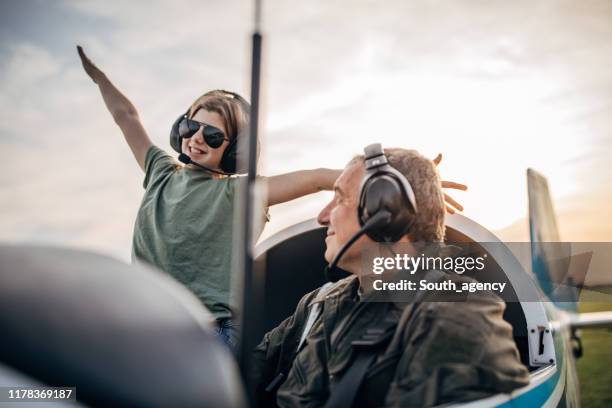 dochter en vader piloot zitten in het vliegtuig - propellervliegtuig stockfoto's en -beelden