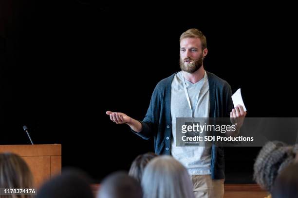 gesturing, um punkt zu machen, mittelerwachsene hipster spricht zu publikum - public speaker stock-fotos und bilder