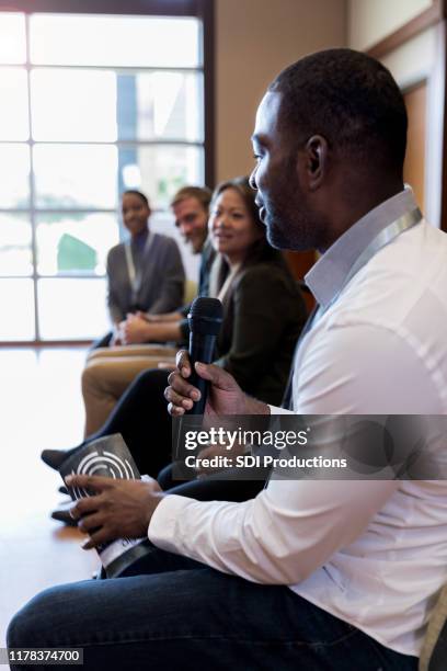 first panel speaker, a mid adult male addresses unseen audience - panel discussion stock pictures, royalty-free photos & images