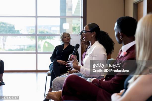 mid adult female panel member gestures and speaks - panelist stock pictures, royalty-free photos & images