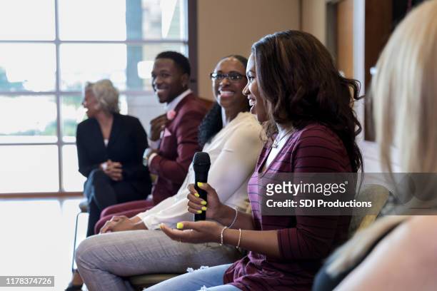 mid adult woman's comments provoke laughter among panel members - panel discussion stock pictures, royalty-free photos & images