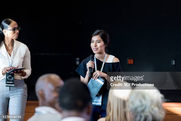 female millennial gives motivational speech to expo audience - participant stock pictures, royalty-free photos & images