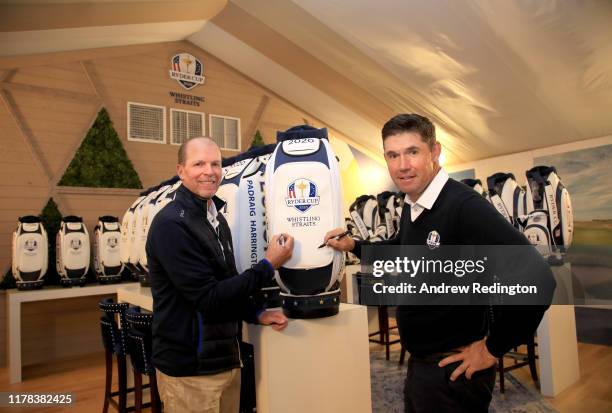 United States Captain Steve Stricker and European Captain Padraig Harrington sign Ryder Cup memorabilia during the Ryder Cup 2020 Year to Go media...