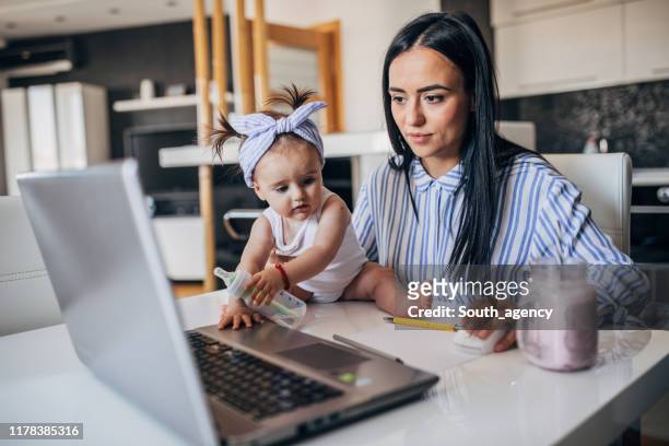 madre y niña trabajando en la computadora portátil - working mother fotografías e imágenes de stock