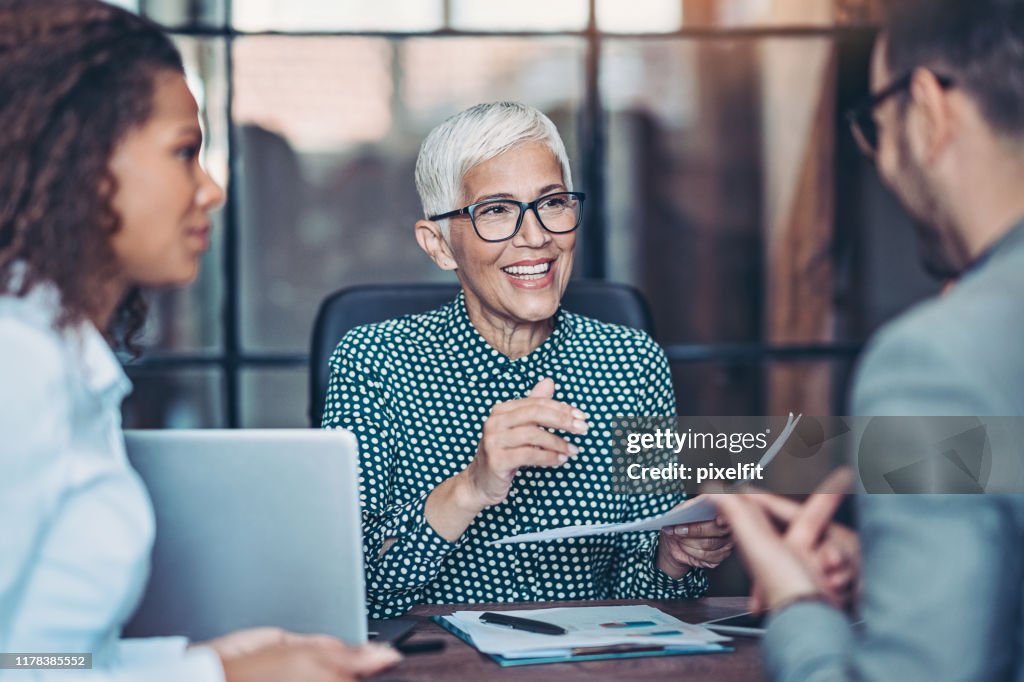 Senior businesswoman talking to her team