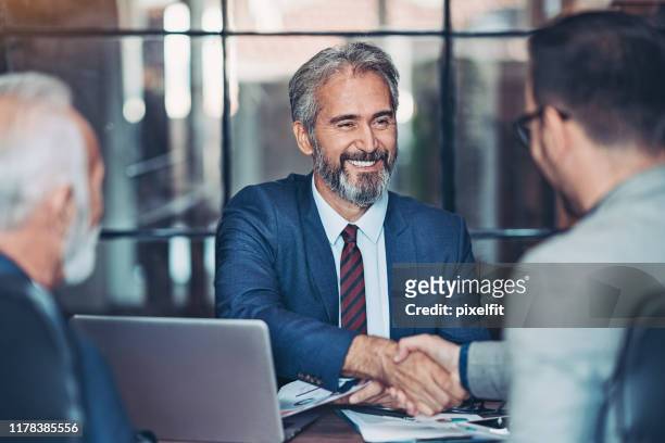 オフィスでビジネスマンの握手 - スーツ　シニア ストックフォトと画像