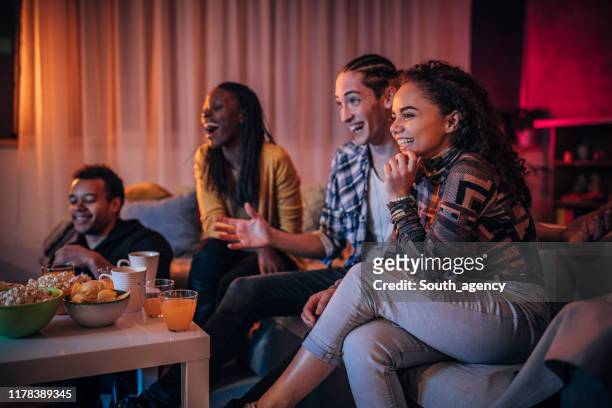 multiethnische freunde schauen gemeinsam fern - college dorm party stock-fotos und bilder