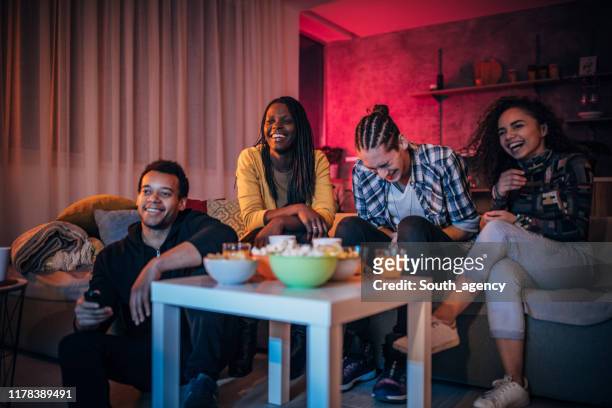 multiethnische freunde schauen gemeinsam fern - college dorm party stock-fotos und bilder