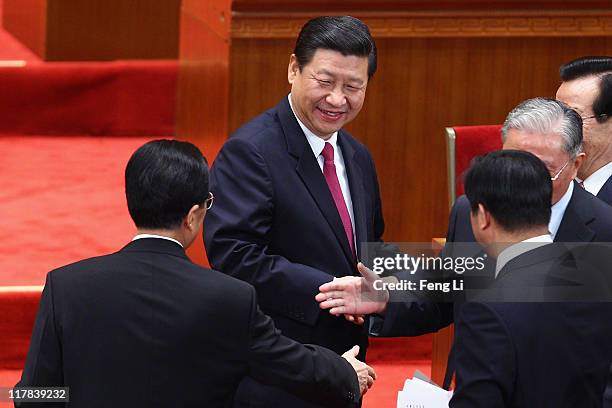 Chinese Vice President Xi Jinping looks at Chinese President Hu Jintao as he shakes hand with former Chinese Vice President Zeng Qinghong after the...