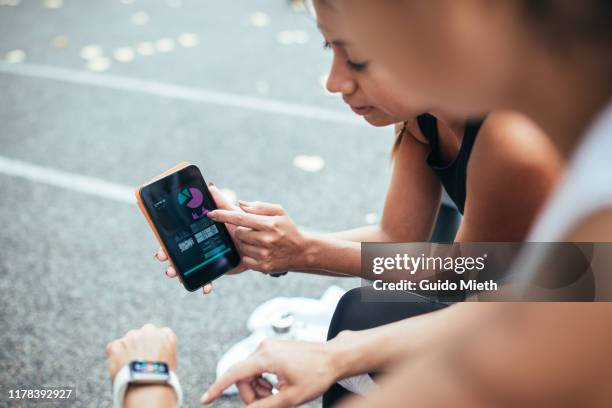 women looking at mobile app after sport. - mobile apps stockfoto's en -beelden