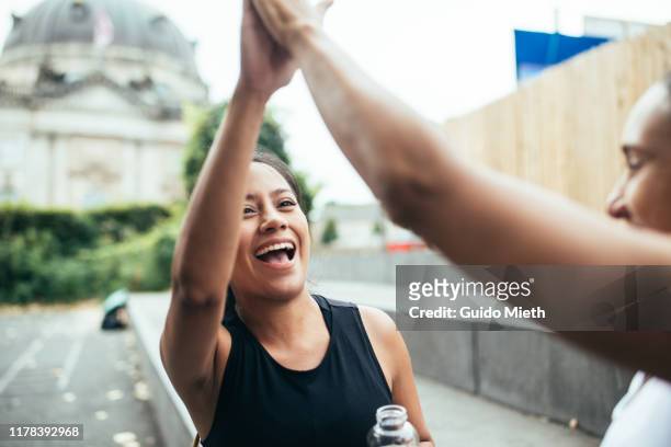 two women giving high five after workout challenge. - no ordinary love stockfoto's en -beelden