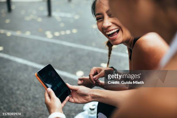 women looking at mobile app after sport. - data selective focus stock pictures, royalty-free photos & images