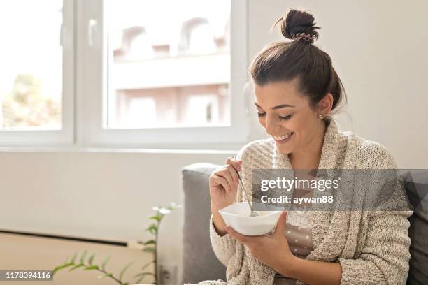 vrouw die een havermout eet - bowl of cereal stockfoto's en -beelden