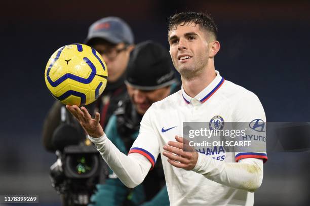 Chelsea's US midfielder Christian Pulisic leaves the pitch holding the match ball after scoring a hattrick to help his team to a 2-4 victory during...