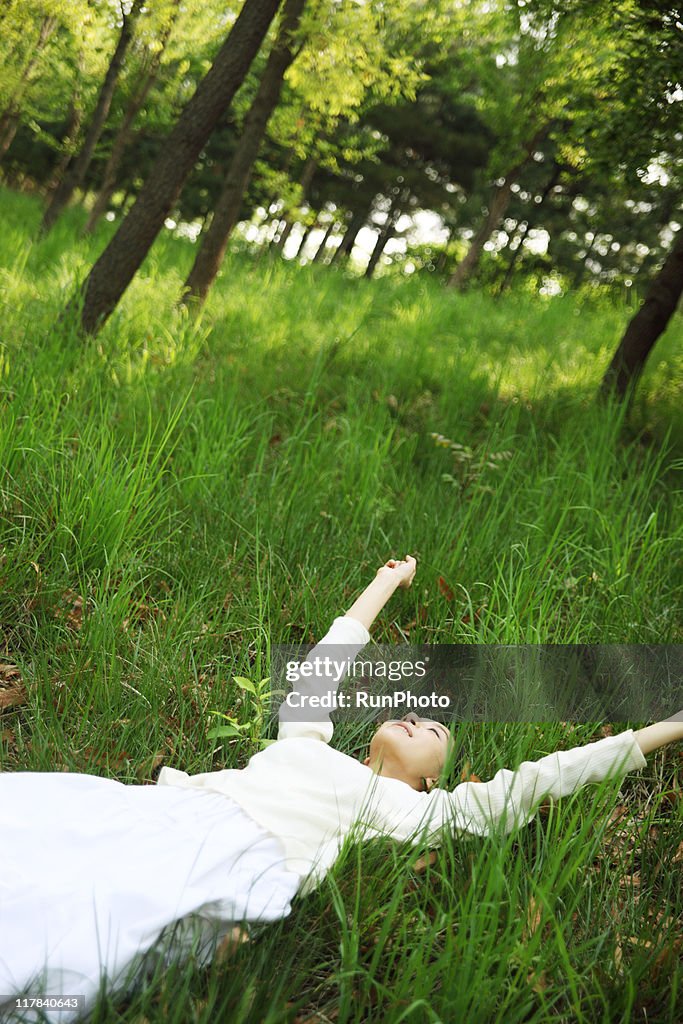 Young woman lying down?in the forest