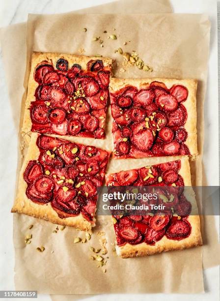 strawberry tart on parchment paper on white background - jordgubbskaka bildbanksfoton och bilder