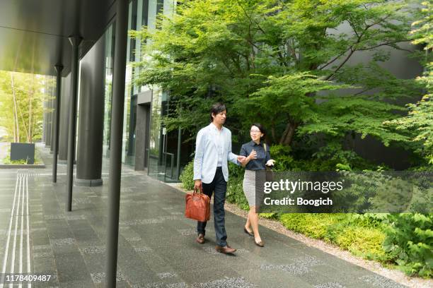 japanese business professionals walking and talking in kyoto office building - two international finance center stock pictures, royalty-free photos & images