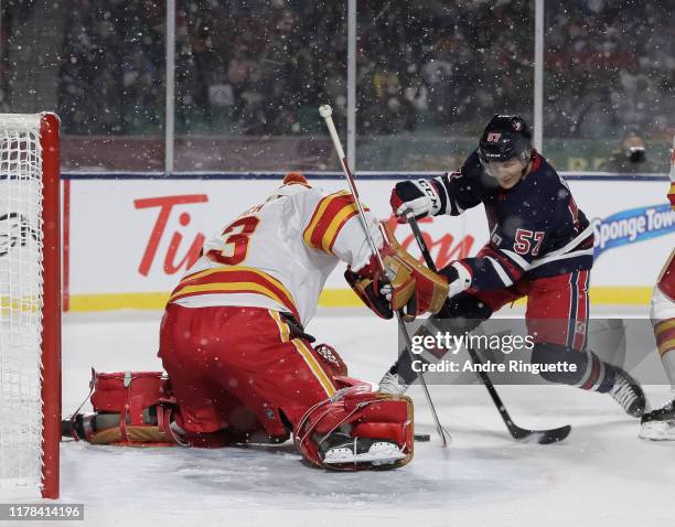 Gabriel Bourque of the Winnipeg Jets gets a shot off on David Rittich of the Calgary Flames during the 2019 Tim Hortons NHL Heritage Classic at...