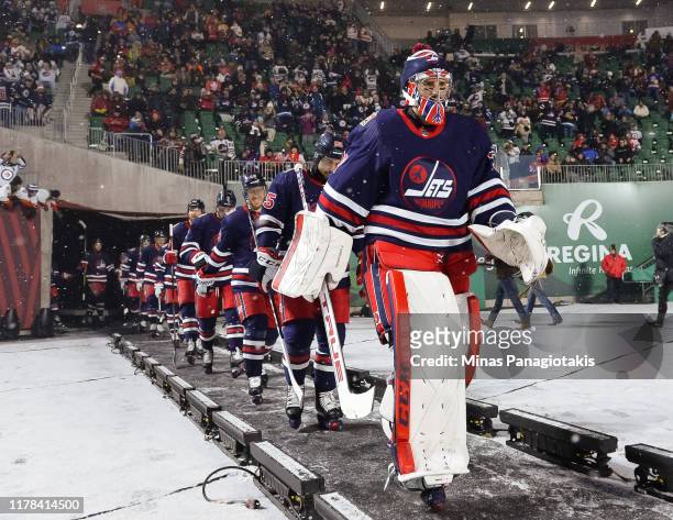 Connor Hellebuyck of the Winnipeg Jets walks to the ice for the second period against the Calgary Flames during the 2019 Tim Hortons NHL Heritage...