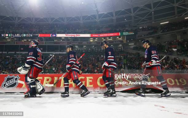 Connor Hellebuyck, Bryan Little, Dmitry Kulikov and Carl Dahlstrom of the Winnipeg Jets walk to the ice for the third period against the Calgary...