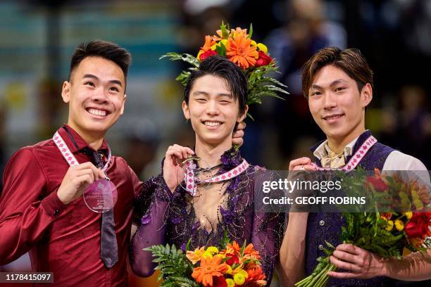 Silver medalist Nam Nguyen of Canada jokes with gold medalist Yuzuru Hanyu of Japan and bronze medalist Keiji Tanaka of Japan during their victory...