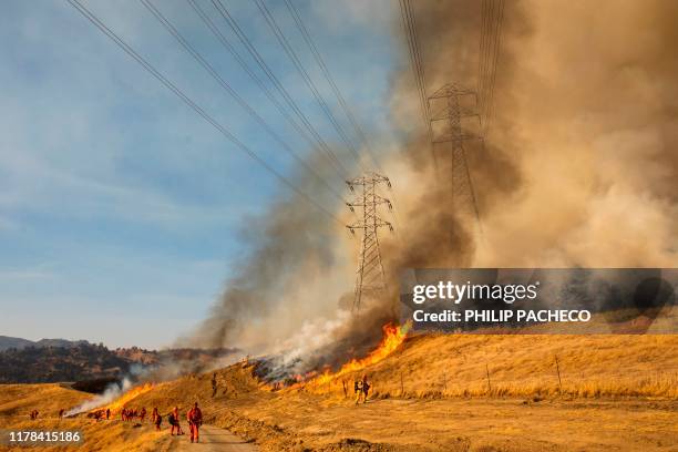 Back fire set by fire fighters burns a hillside near PG&E power lines during firefighting operations to battle the Kincade Fire in Healdsburg,...