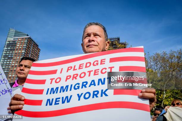 Participant holding a protest sign at the rally. Immigration advocates and allies gathered at Battery Park to launch an 18-day march to Washington,...