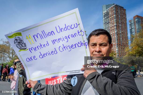 Participant holding a protest sign at the rally. Immigration advocates and allies gathered at Battery Park to launch an 18-day march to Washington,...