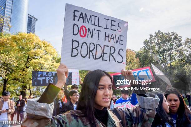 Participant holding a protest sign at the rally. Immigration advocates and allies gathered at Battery Park to launch an 18-day march to Washington,...