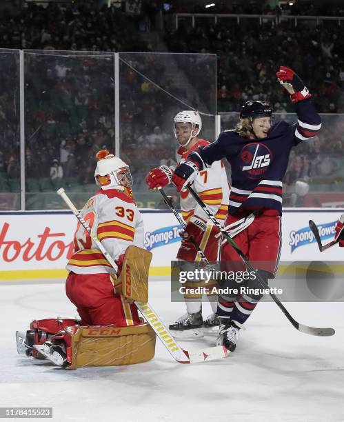 Kyle Connor of the Winnipeg Jets celebrates after a third period goal from teammate Josh Morrissey on David Rittich of the Calgary Flames during the...