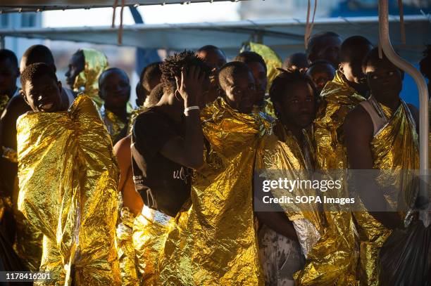 Sub Saharan migrants standing on a patrol vessel covered with thermal blankets after the rescue. The ship Jean Francois Deniau, a Frontex French...