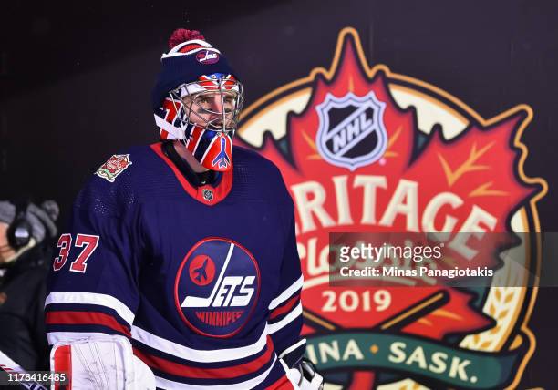 Connor Hellebuyck of the Winnipeg Jets walks to the ice to start the third period against the Calgary Flames during the 2019 Tim Hortons NHL Heritage...