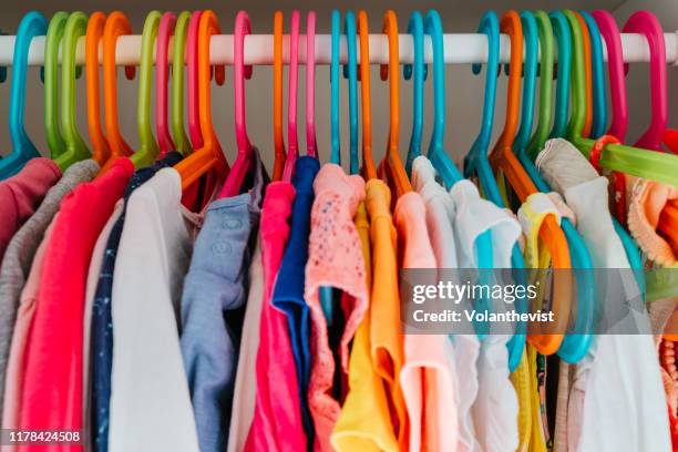 clothes wardrobe full of colored clothes hanging - hanging clothes stock pictures, royalty-free photos & images