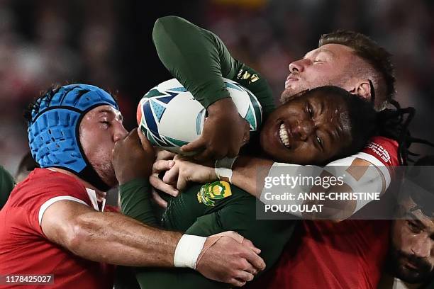 South Africa's wing S'Busiso Nkosi is tackled by Wales' flanker Justin Tipuric and Wales' fly-half Dan Biggar during the Japan 2019 Rugby World Cup...