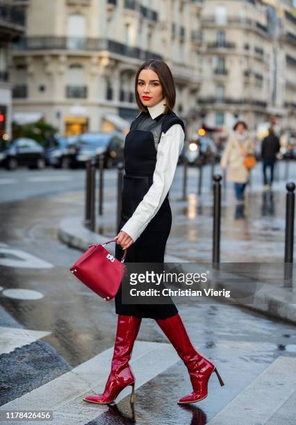 Olivia Culpo is seen wearing total look Fendi: black sheer dress, white button shirt, red bag and boots during Paris Fashion Week Womenswear Spring...