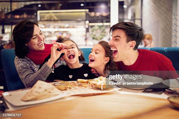 portret van happy family eten in het restaurant met kerstmis - eating food happy stockfoto's en -beelden