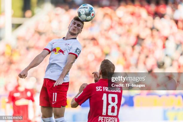 Timo Werner of RB Leipzig and Nils Petersen of Sport Club Freiburg battle for the ball during the Bundesliga match between Sport-Club Freiburg and RB...