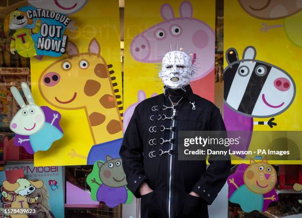 Goth poses for a photo in front of a shop window featuring Peppa Pig during the Whitby Goth Weekend in Whitby, Yorkshire, as hundreds of goths...