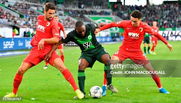 Augsburg's German midfielder Rani Khedira and Augsburg's Swiss midfielder Ruben Vargas block Wolfsburg's French defender Jerome Roussillon during the...