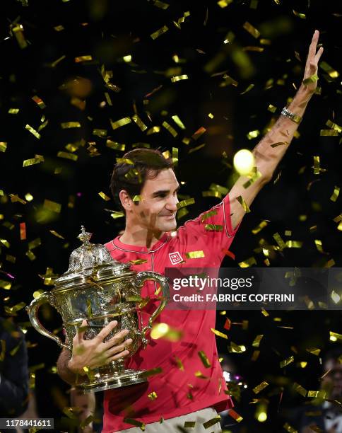 Swiss Roger Federer holds the trophy after his 10th victory at the Swiss Indoors tennis tournament in Basel on October 27, 2019.