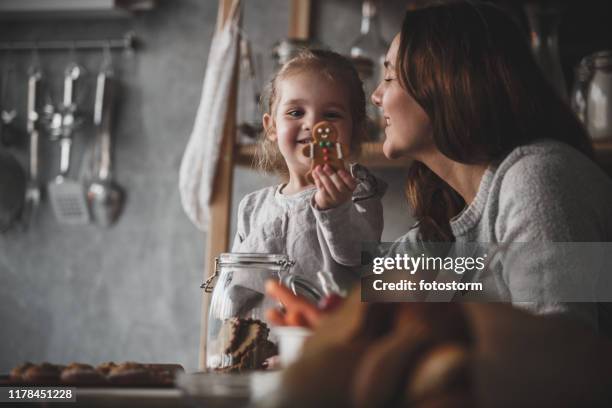 happy mother and her toddler daughter enjoying cookies together - child cookie jar stock pictures, royalty-free photos & images