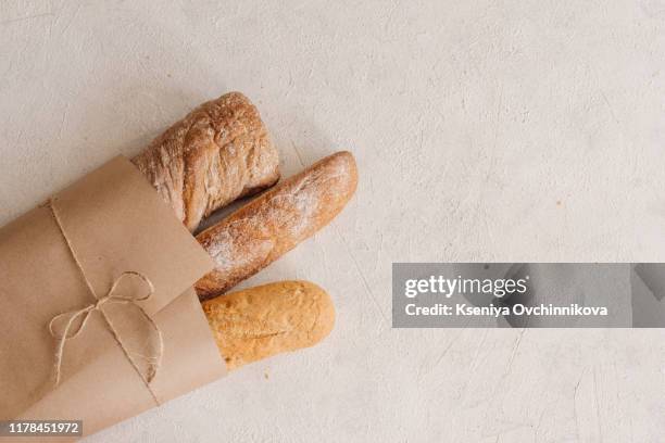 freshly baked bread on wooden cutting board isolated on white background, top view - bread texture stock-fotos und bilder