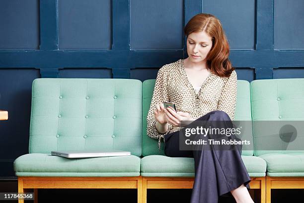 woman using smart phone on sofa. - formalwear fotografías e imágenes de stock