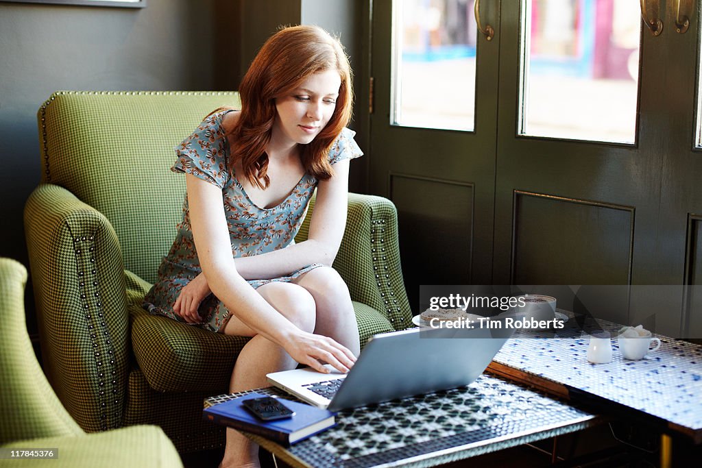 Woman in coffee shop using laptop.