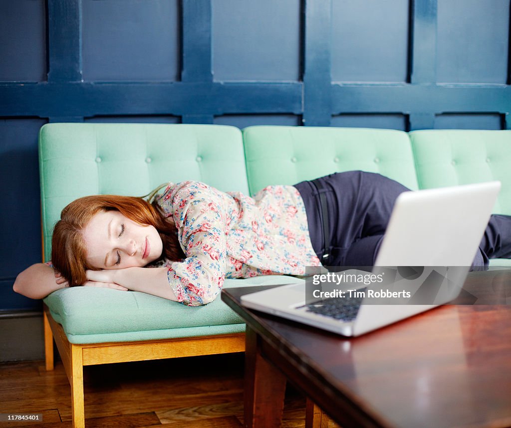 Woman asleep on sofa with laptop