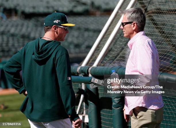 Oakland Athletics manager Bob Melvin talks with A's executive vice president of baseball operations and minority owner Billy Beane during their...