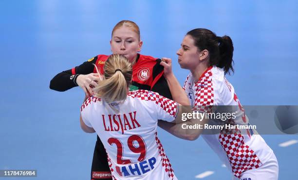 Meike Schmelzer of Germany is attacked by Ines Lisjak and Ivana Dezic during the friendly match as part of the 'Tag des Handballs' between Germany...