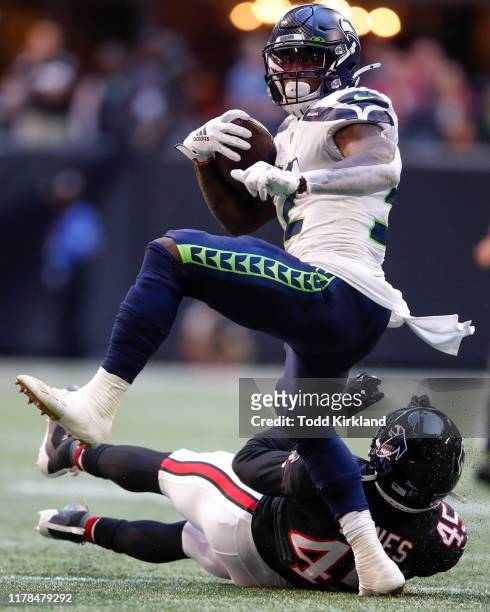 Chris Carson of the Seattle Seahawks breaks away from Deion Jones of the Atlanta Falcons in the first half of an NFL game at Mercedes-Benz Stadium on...