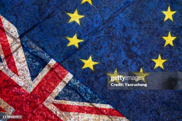 brexit, flags of the united kingdom and the european union on cracked background - brexit stockfoto's en -beelden