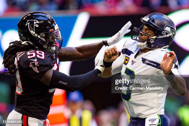 Russell Wilson of the Seattle Seahawks under pressure from De'Vondre Campbell of the Atlanta Falcons during the first half of a game at Mercedes-Benz...